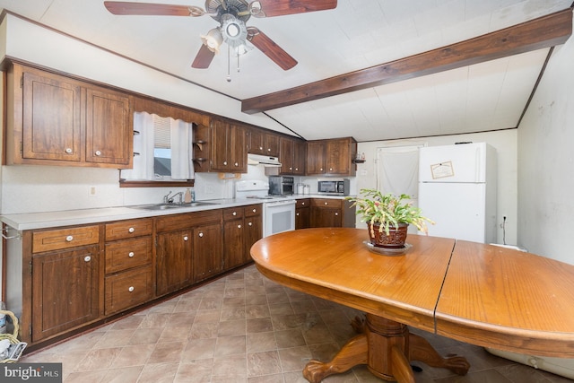 kitchen with white appliances, under cabinet range hood, light countertops, and a sink