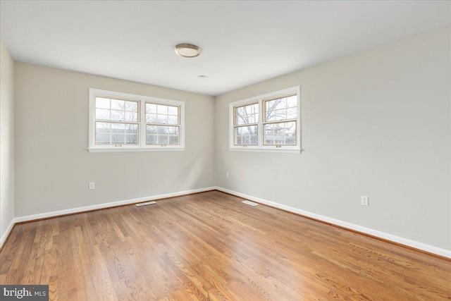 empty room featuring wood-type flooring and a wealth of natural light