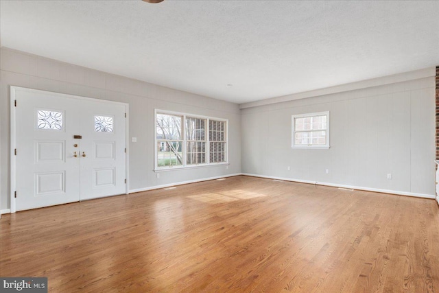 entrance foyer with light hardwood / wood-style floors and a textured ceiling