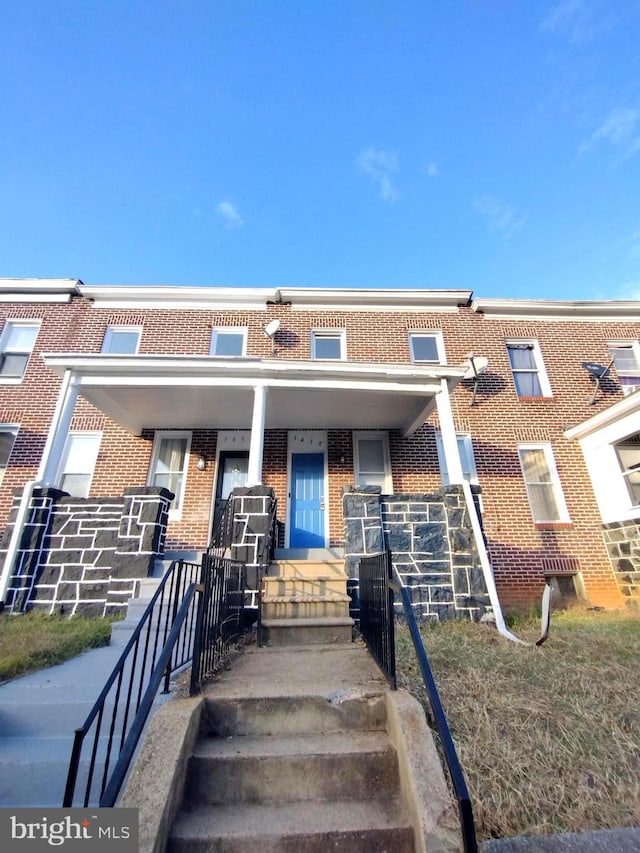 townhome / multi-family property featuring covered porch