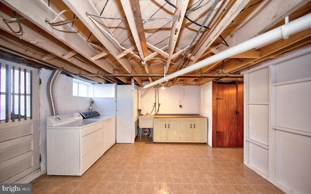 basement with washer and clothes dryer and sink