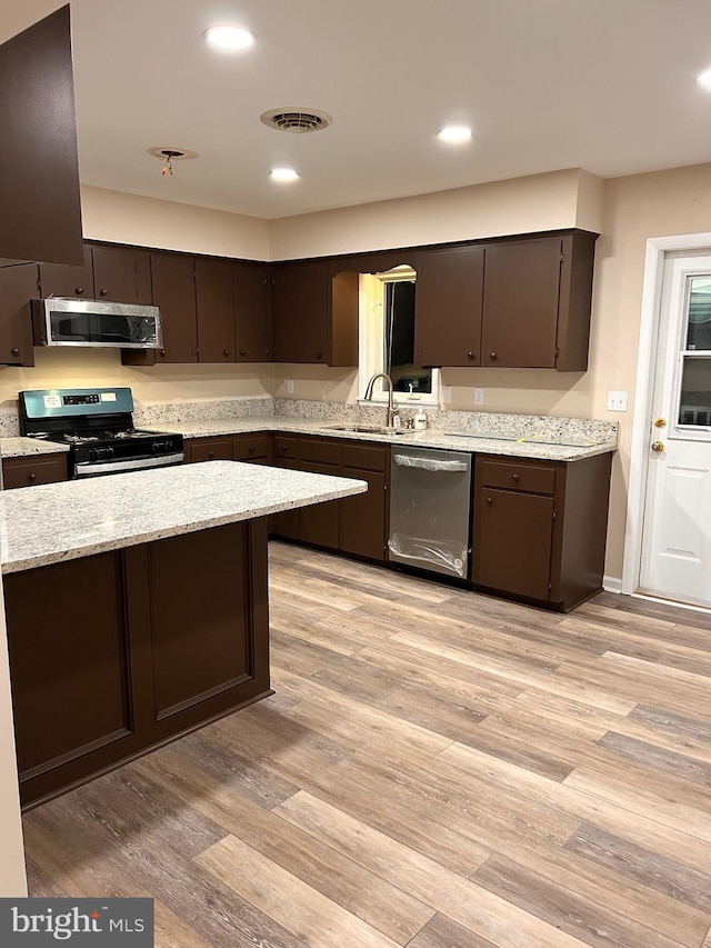 kitchen with light hardwood / wood-style flooring, sink, dark brown cabinets, and appliances with stainless steel finishes