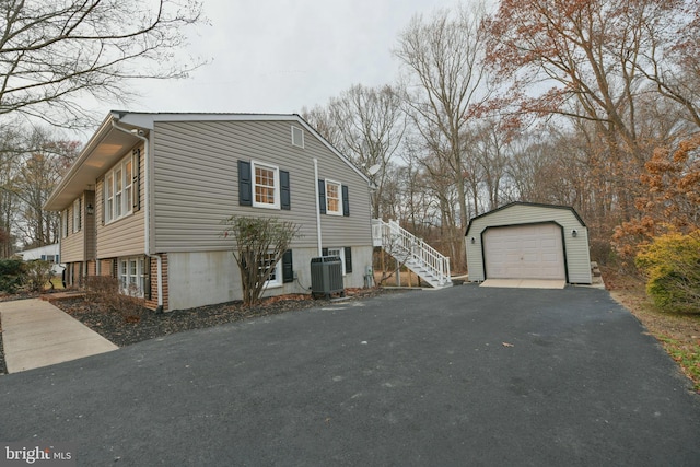 view of home's exterior featuring a garage, an outdoor structure, and central air condition unit