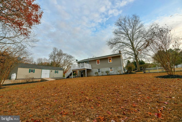 back of property featuring a lawn and a deck