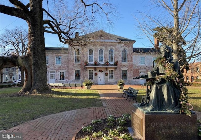 view of front of house with a balcony and a front yard