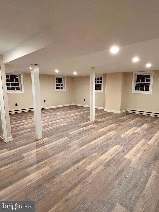 basement featuring hardwood / wood-style flooring and a baseboard radiator