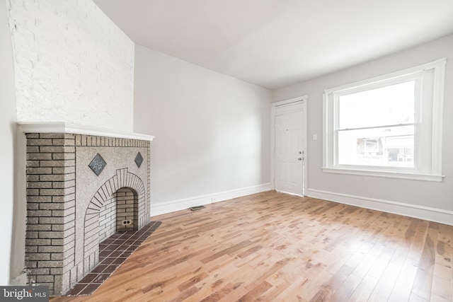 unfurnished living room featuring a fireplace and hardwood / wood-style floors