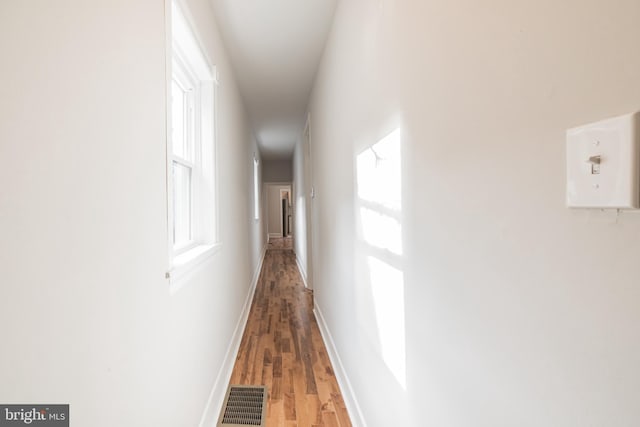 hallway with hardwood / wood-style flooring