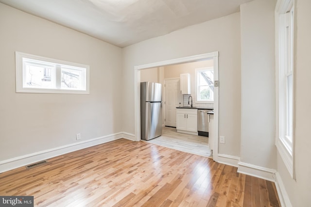 empty room with sink and light hardwood / wood-style floors