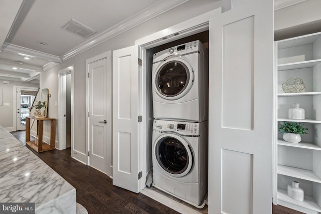 washroom featuring dark hardwood / wood-style floors, stacked washer / dryer, and ornamental molding