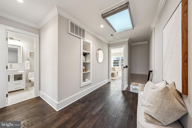 hallway featuring crown molding, dark hardwood / wood-style flooring, sink, and a skylight