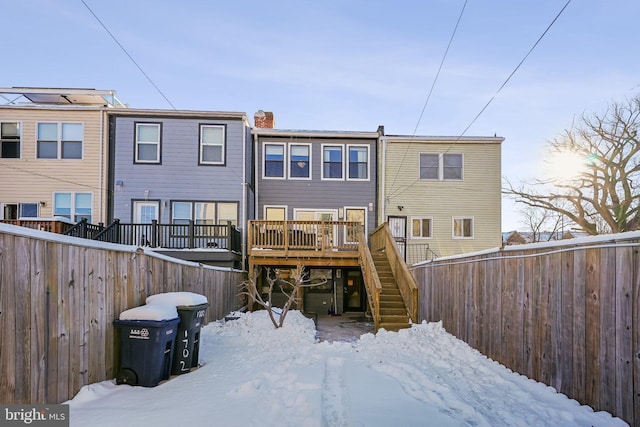 snow covered house featuring a deck