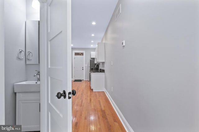 hall featuring light wood-type flooring and sink