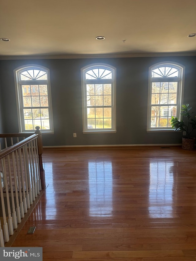 unfurnished room featuring dark wood-type flooring and ornamental molding