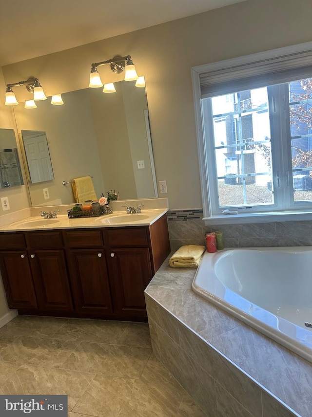 bathroom with vanity and tiled bath