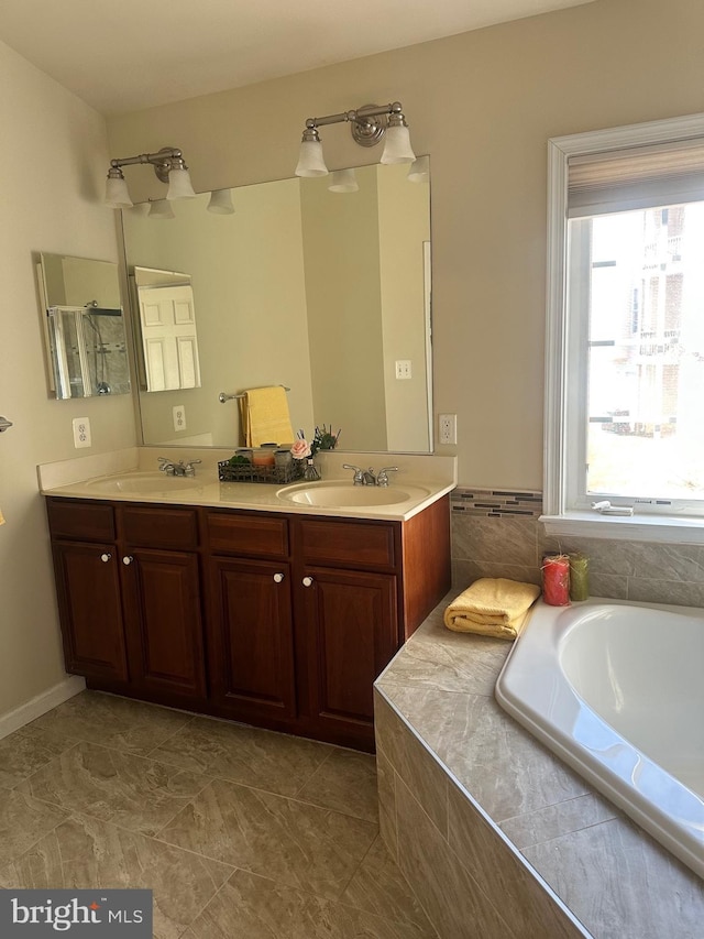 bathroom with vanity and tiled bath