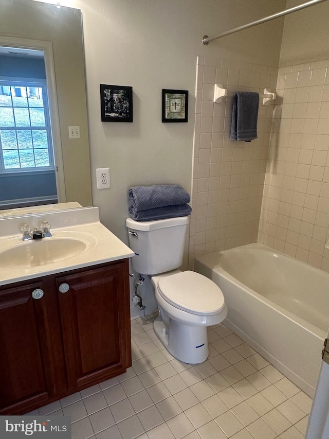 full bathroom featuring tiled shower / bath combo, vanity, tile patterned floors, and toilet