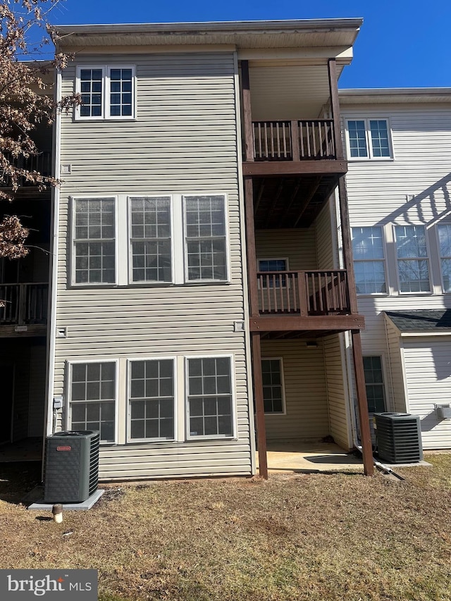 back of property featuring central AC, a yard, and a patio