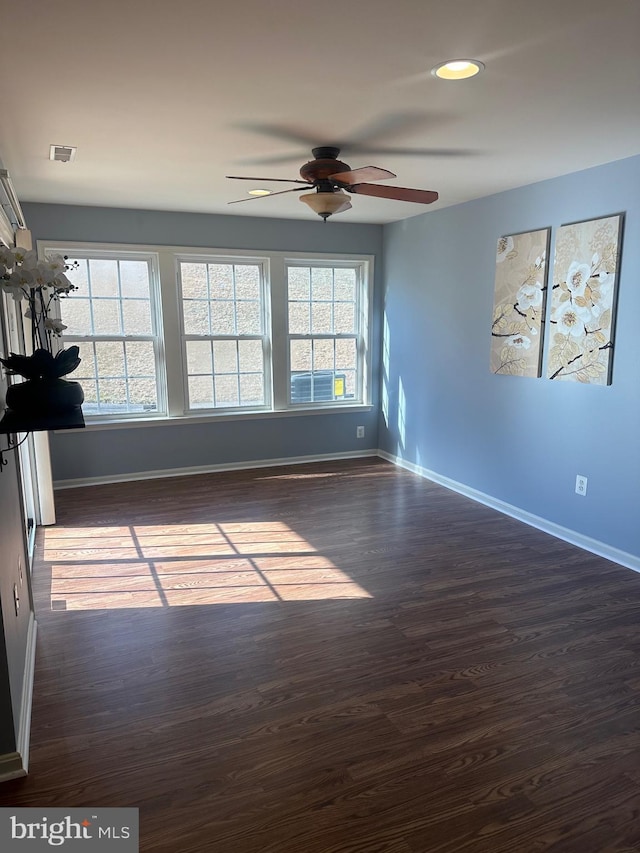 spare room with ceiling fan, plenty of natural light, and dark hardwood / wood-style floors