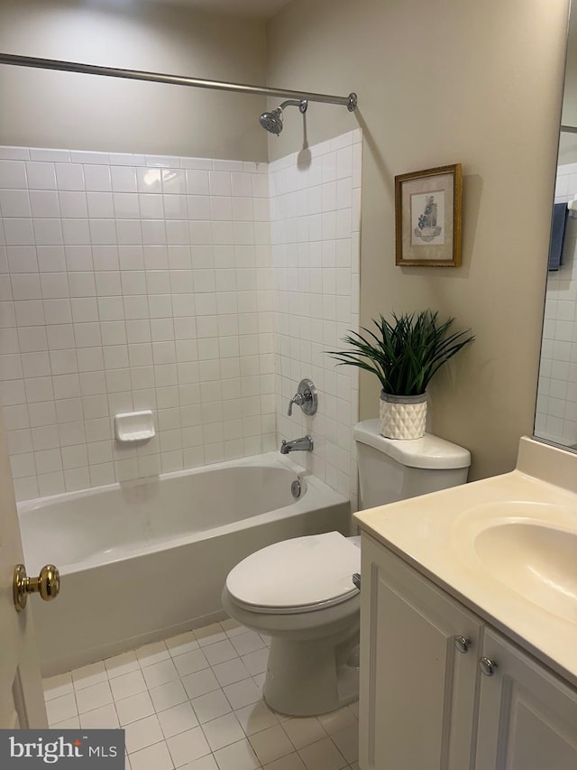 full bathroom featuring vanity, tile patterned flooring, toilet, and tiled shower / bath