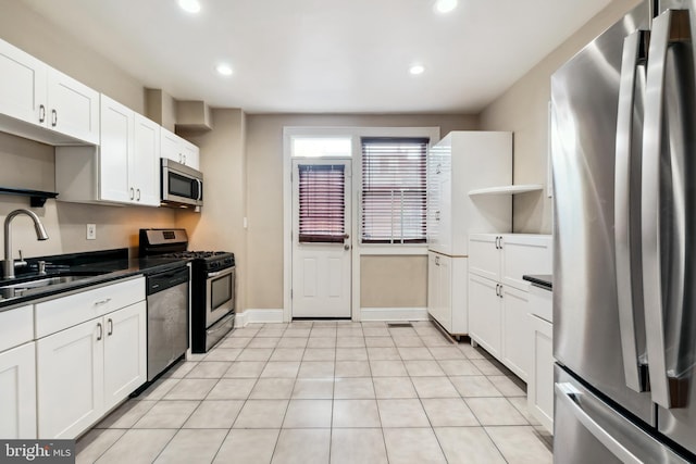 kitchen featuring white cabinets, sink, light tile patterned floors, and stainless steel appliances