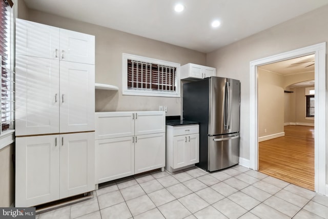 kitchen featuring stainless steel refrigerator, white cabinets, and light hardwood / wood-style floors