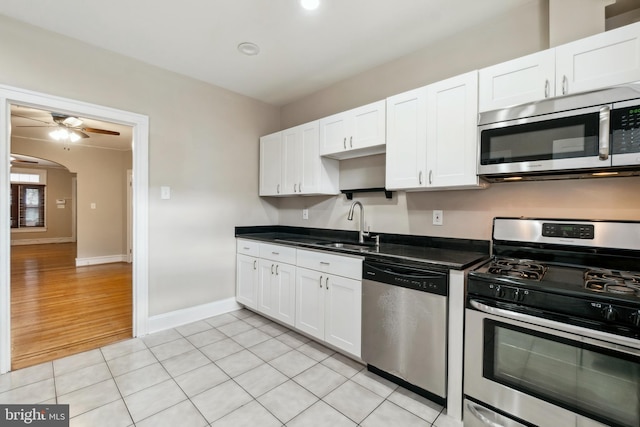 kitchen with white cabinets, sink, ceiling fan, light wood-type flooring, and appliances with stainless steel finishes