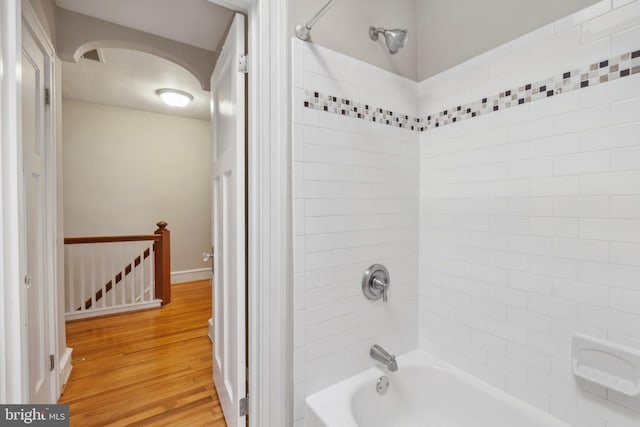 bathroom with wood-type flooring and tiled shower / bath