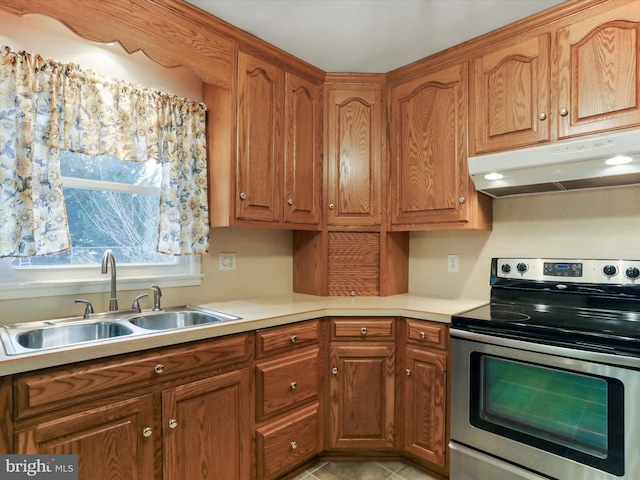 kitchen with electric stove, sink, and light tile patterned floors