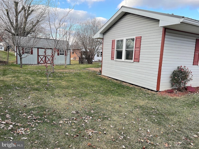 view of side of home with a lawn and an outdoor structure