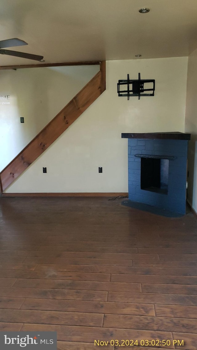 unfurnished living room featuring a fireplace and dark hardwood / wood-style floors