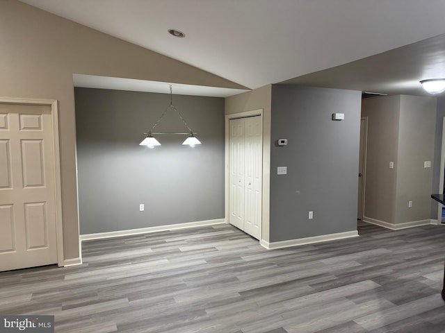 interior space with light hardwood / wood-style floors and lofted ceiling