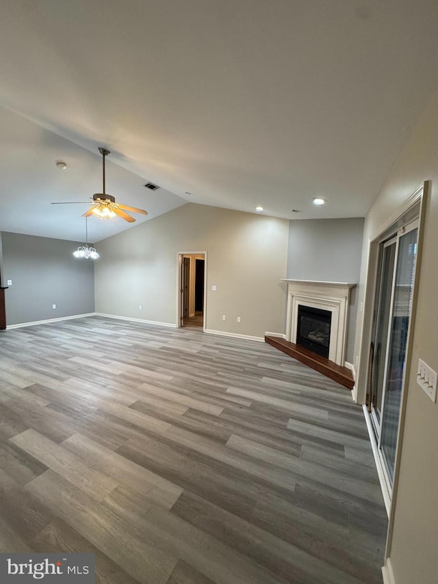 unfurnished living room with ceiling fan, hardwood / wood-style floors, and lofted ceiling