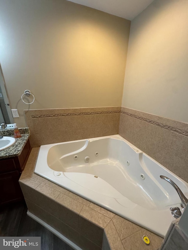 bathroom featuring vanity and a relaxing tiled tub