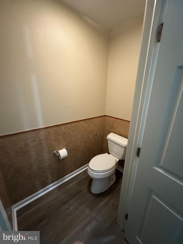 bathroom with hardwood / wood-style flooring and toilet