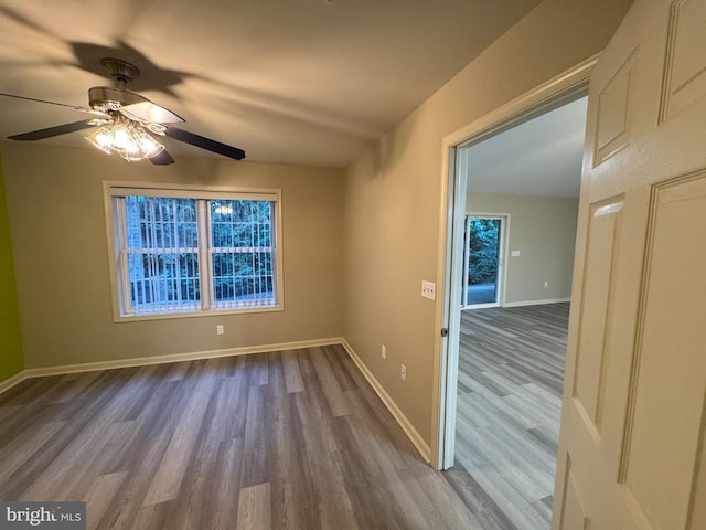 spare room featuring ceiling fan, a healthy amount of sunlight, and hardwood / wood-style flooring