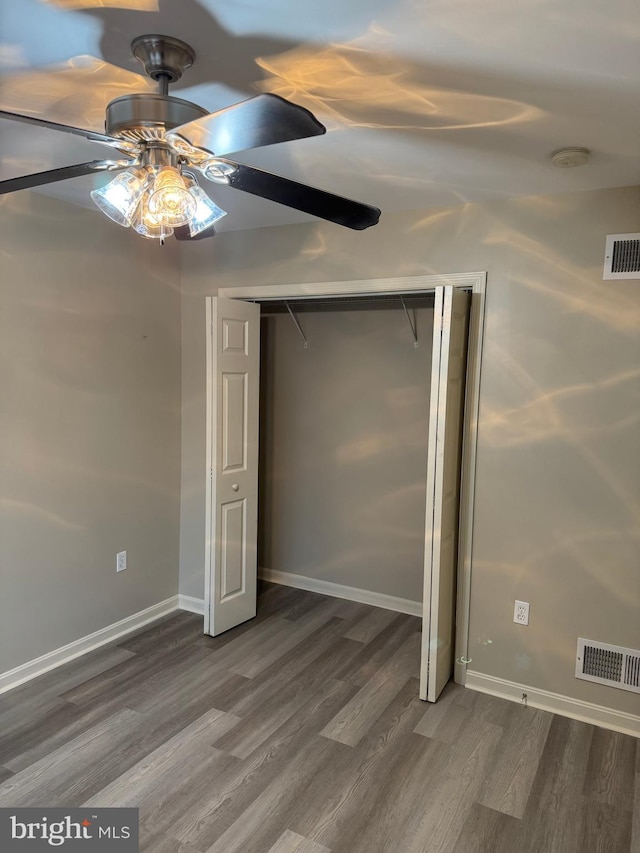 unfurnished bedroom with wood-type flooring, a closet, and ceiling fan