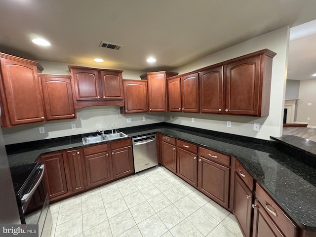 kitchen with dishwasher, sink, dark stone countertops, light tile patterned floors, and black / electric stove