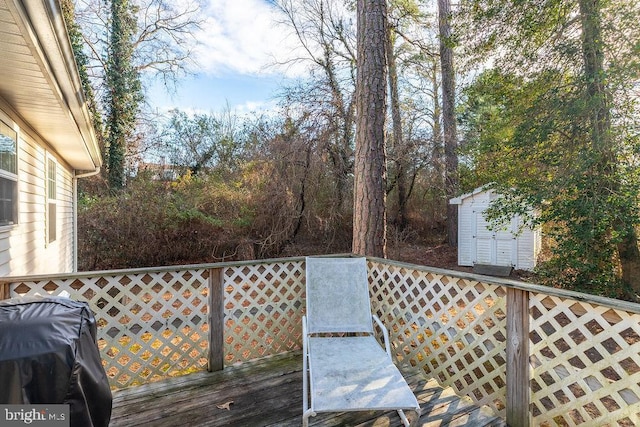 wooden deck with a storage unit and a grill