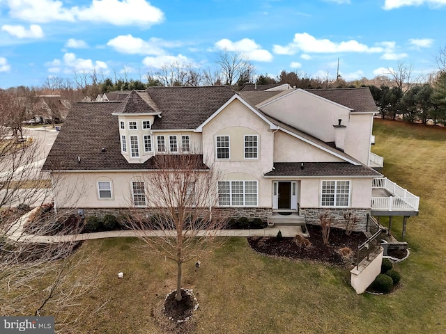 rear view of property featuring a wooden deck and a yard