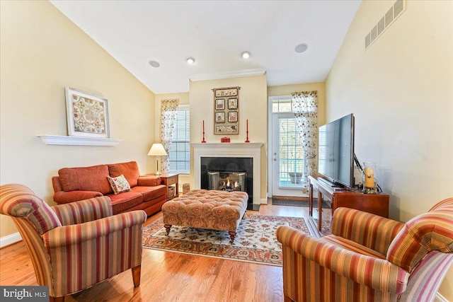 living room featuring vaulted ceiling, plenty of natural light, and light hardwood / wood-style floors