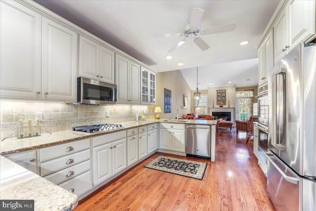 kitchen featuring white cabinets, stainless steel appliances, and vaulted ceiling