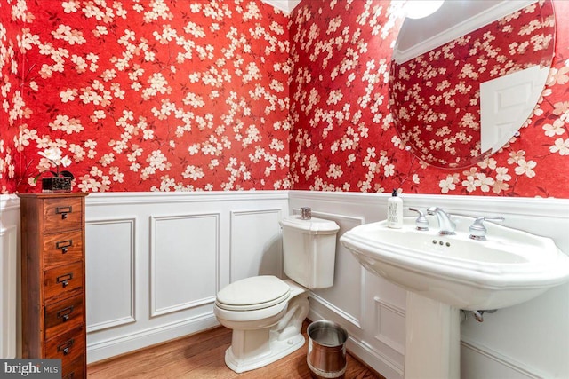 bathroom featuring toilet, wood-type flooring, and ornamental molding