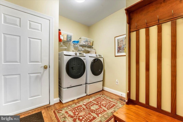 washroom with light wood-type flooring and washing machine and clothes dryer