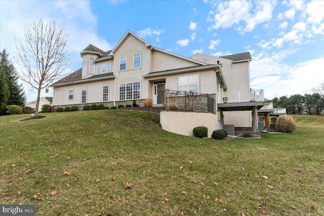 rear view of property with central AC, a deck, and a yard