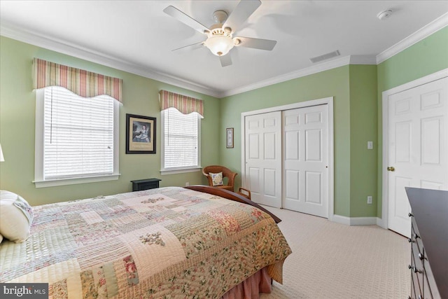 carpeted bedroom featuring ceiling fan, a closet, and crown molding