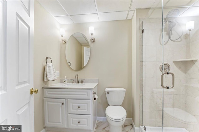 bathroom featuring toilet, a paneled ceiling, walk in shower, and vanity