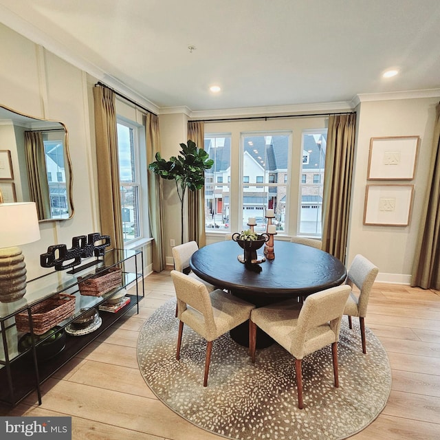 dining area featuring light wood-type flooring and crown molding