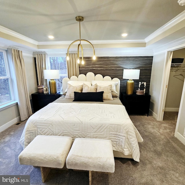 bedroom featuring a walk in closet, a closet, carpet, and ornamental molding