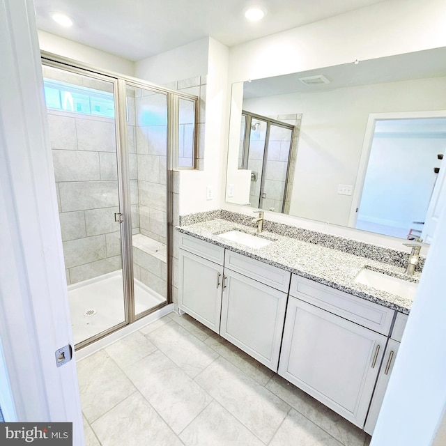 bathroom with a shower with door and vanity